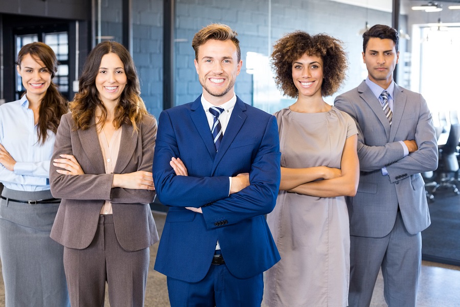 Portrait of confident business team standing in office with their hands crossed