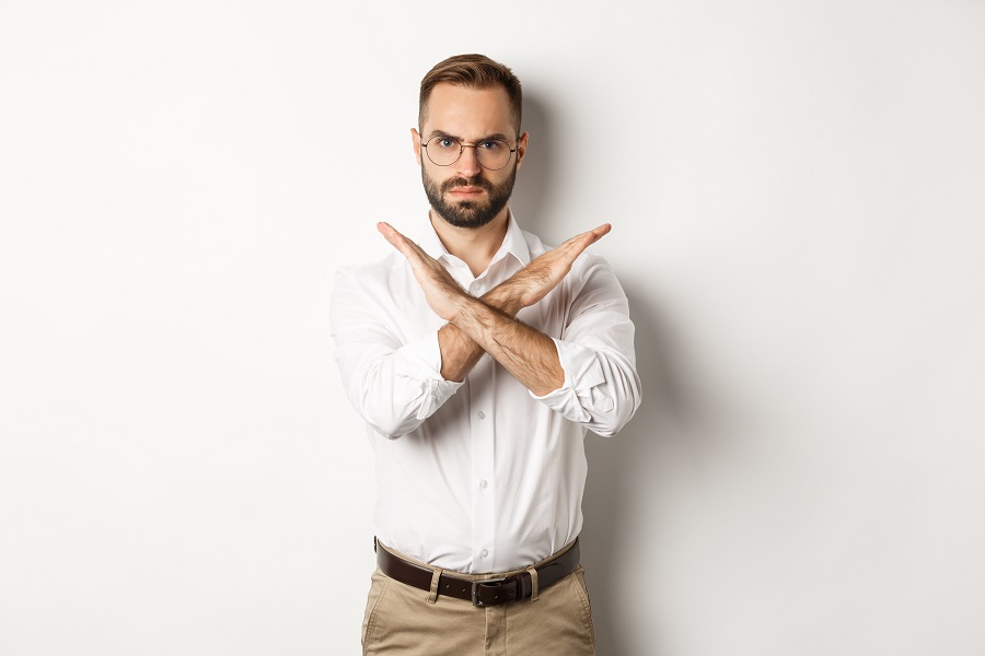 Angry businessman frowning and showing cross, stop you, telling no and prohibit something, standing over white background