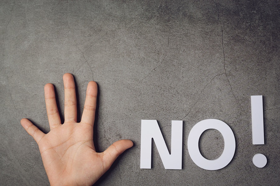 word "NO" with child's hand on dark background
