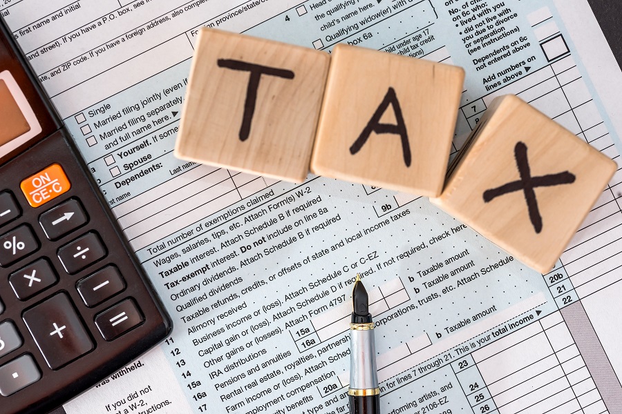 1040 tax form and wooden cubes, calculator and pen